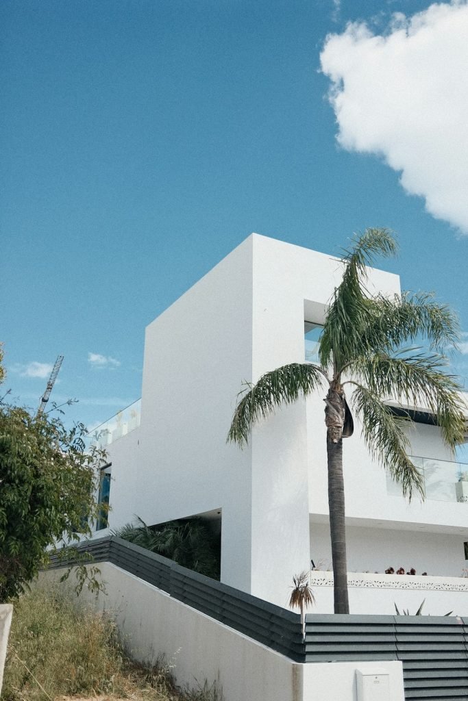 modern-white-building-with-palm-tree-and-blue-sky-4uqt9kdg83u